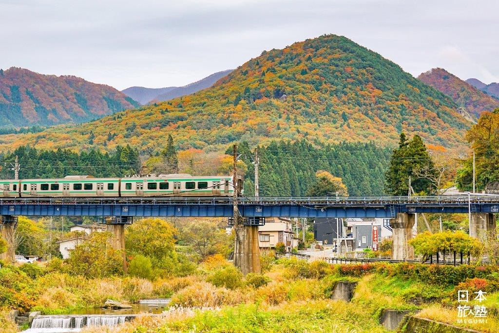 從山寺寶珠橋眺望電車行過川上的景致，季節感十足