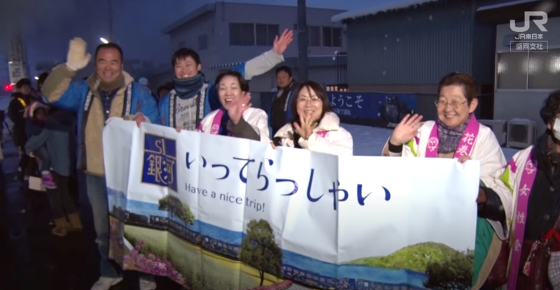 Local volunteers wishing train passengers a safe trip. (Image credit: JR East Morioka Branch)